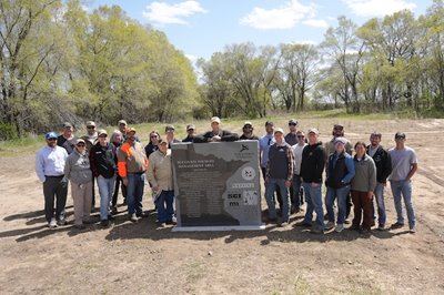 Group of visitors pose in front of the signage dedicating the Succonix WMA.