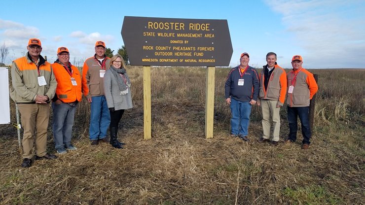 Visitors in front of a sign for the Rooster Ridge Wildlife Management Area in Minnesota.