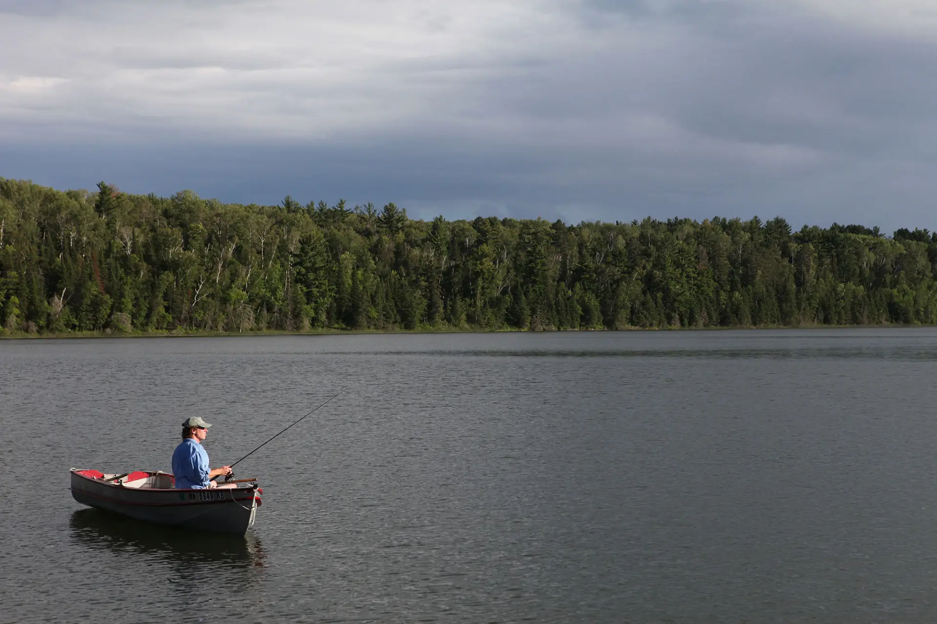 A fisherman casts a line from a boat on La Salle Lake.